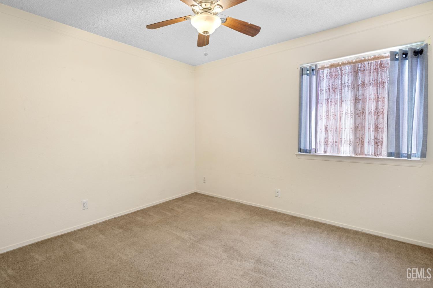 Undisclosed Address Bakersfield, CA 93312 - Photo 33 of 40 an empty room with a window and a ceiling fan