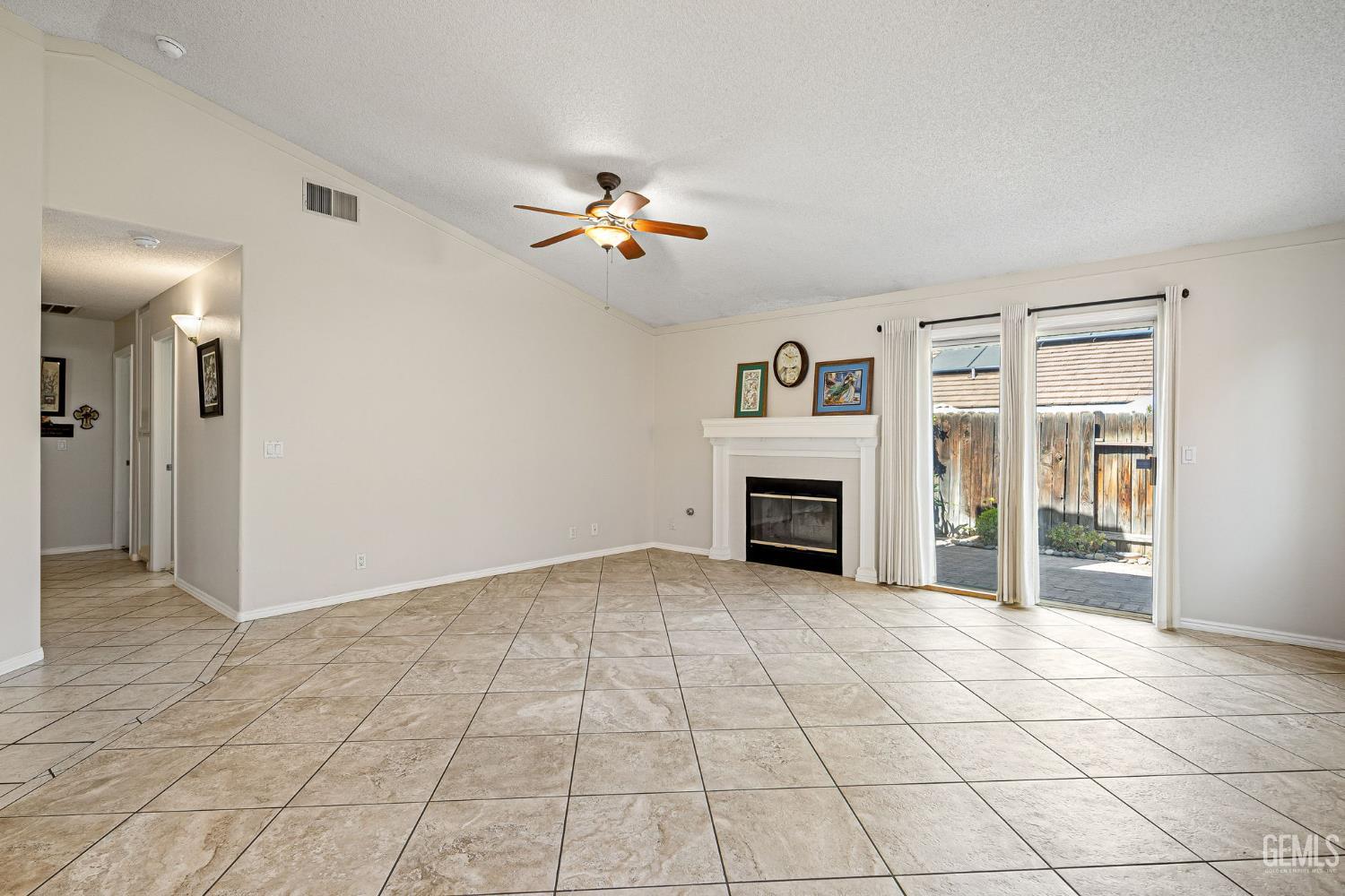 Undisclosed Address Bakersfield, CA 93312 - Photo 10 of 40 an empty room with windows and fireplace