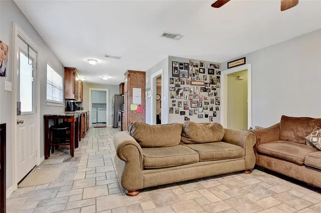 a living room with furniture kitchen view and a large window
