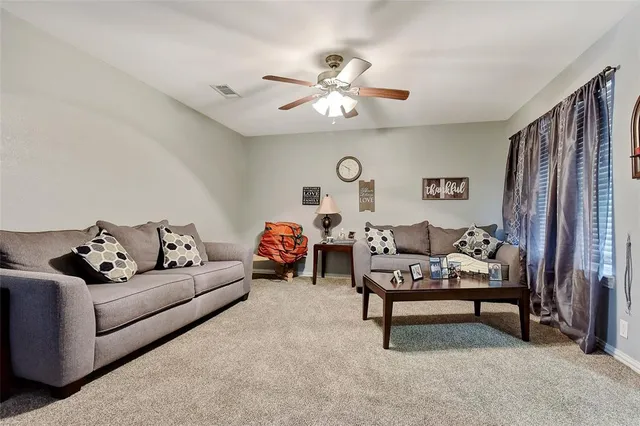 a living room with furniture and a ceiling fan