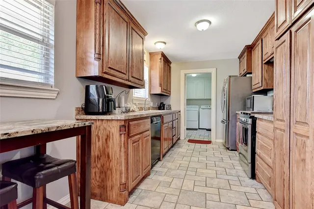a kitchen with stainless steel appliances granite countertop a refrigerator and a stove