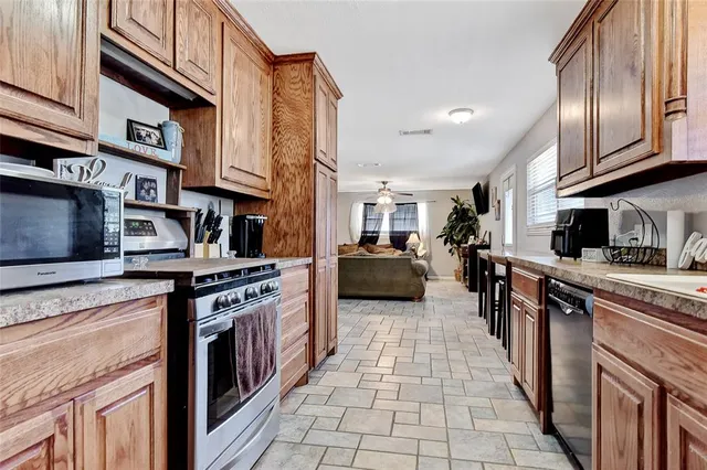 a kitchen with stainless steel appliances granite countertop a stove top oven a sink dishwasher and cabinets