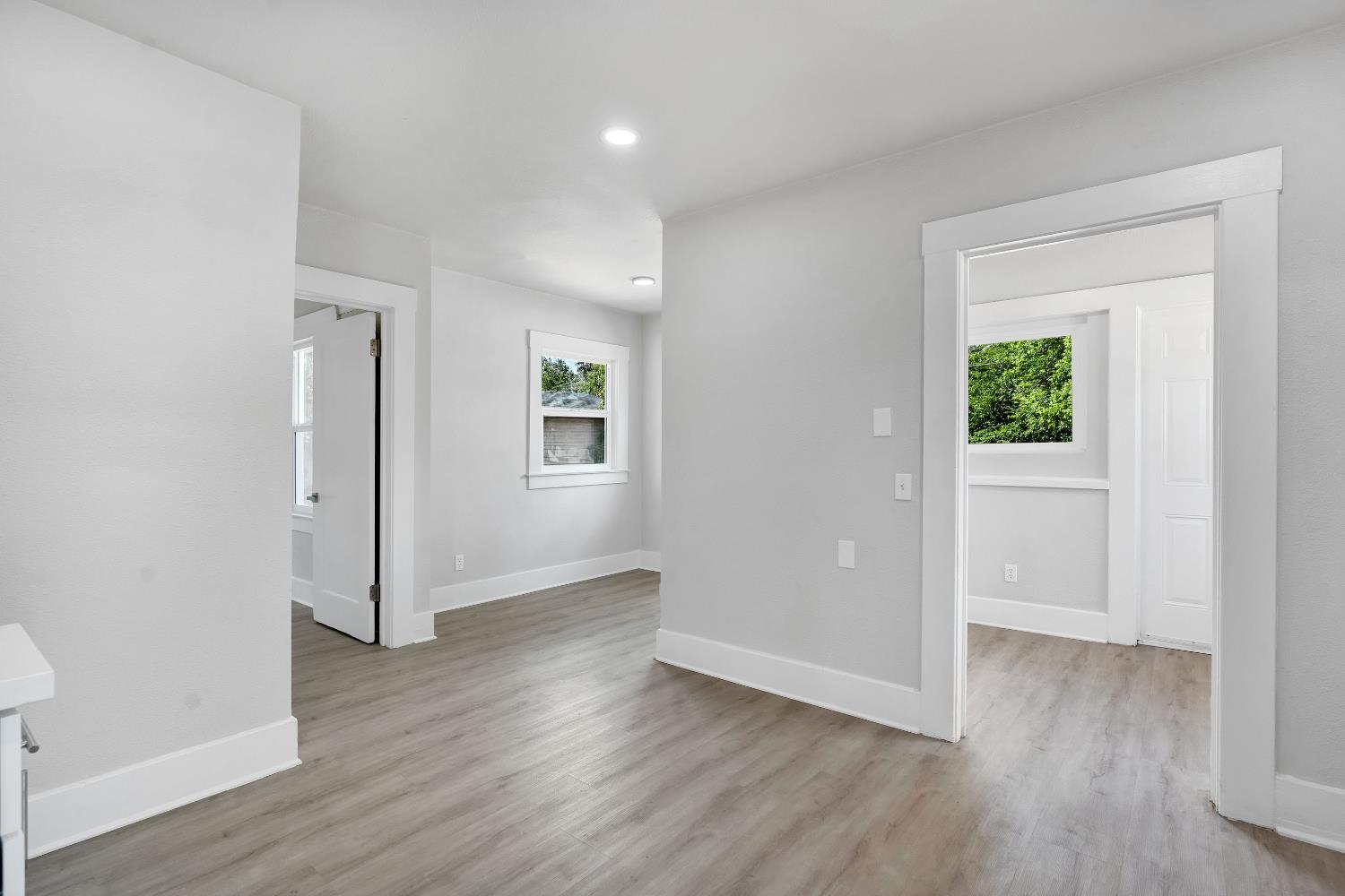 3935 East Balch Avenue Fresno, CA 93702 - Photo 13 of 25 an empty room with wooden floor and windows