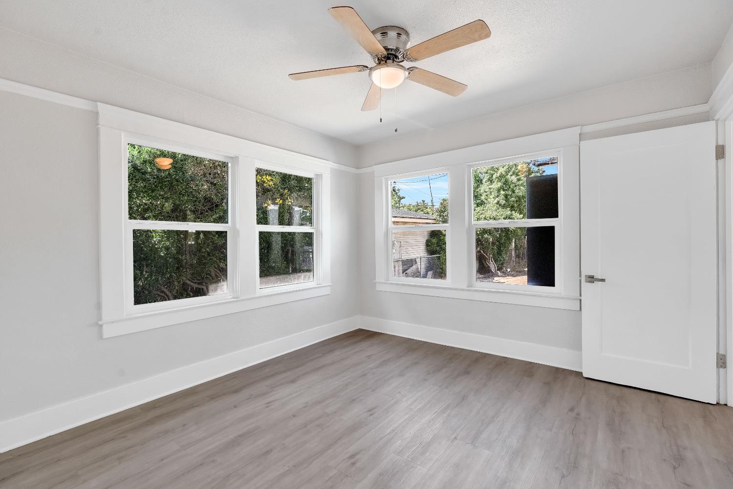 3935 East Balch Avenue Fresno, CA 93702 - Photo 21 of 25 a view of an empty room with wooden floor and a window