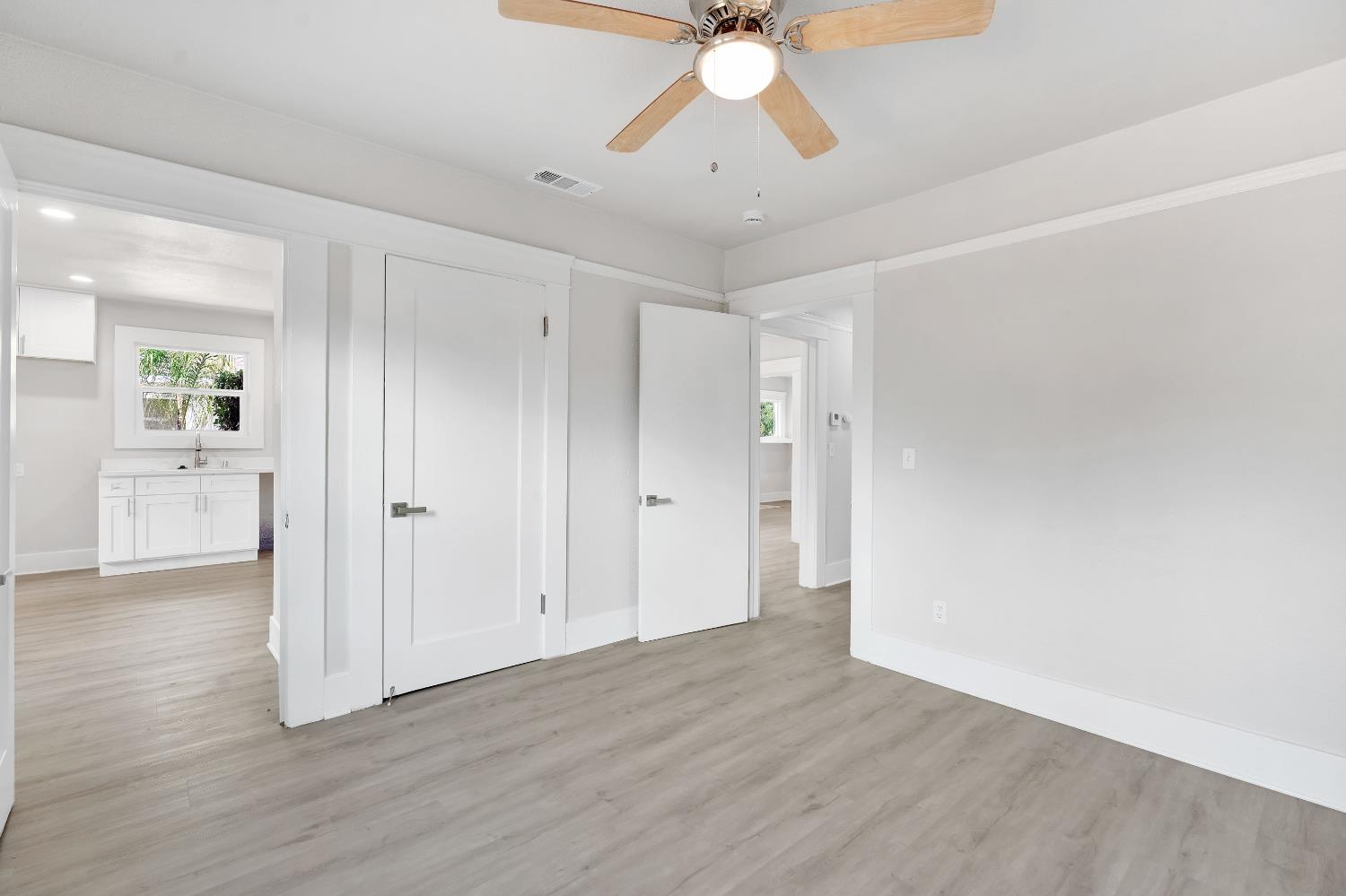 3935 East Balch Avenue Fresno, CA 93702 - Photo 22 of 25 an empty room with wooden floor and a ceiling fan