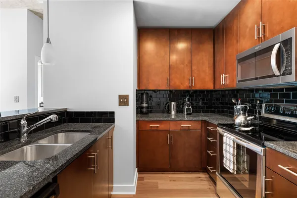 a dining hall with stainless steel appliances kitchen island granite countertop furniture and wooden floor