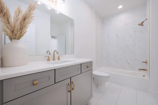 a bathroom with a sink a toilet and shower