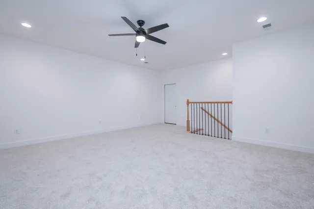 an empty room with a ceiling fan and a window