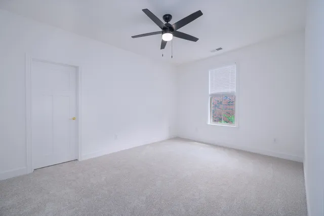 an empty room with a window and a fan