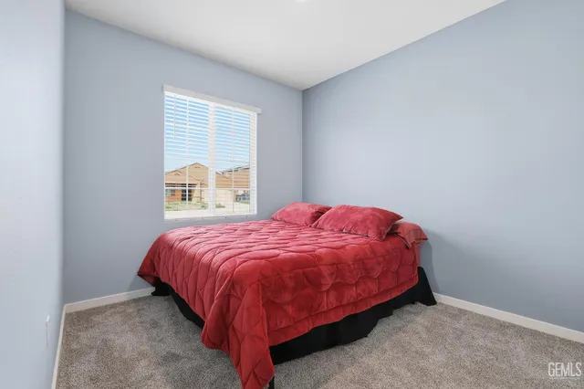 a bed sitting in a bedroom next to a window