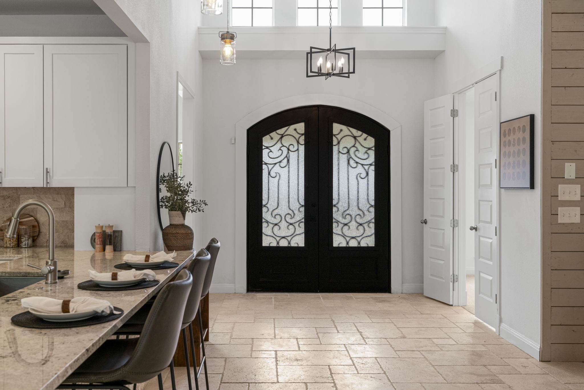 1129 Cedar Pass Road Driftwood, TX 78619 - Photo 4 of 40 Standing at the entry, you can really see the "wow" factor. Those arched double doors with the iron scrollwork are just beautiful against the white walls and high ceilings. It sets such a sophisticated tone the moment someone walks in.