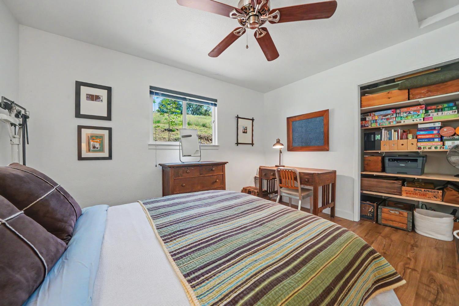 16308 Emigrant Trail Volcano, CA 95689 - Photo 22 of 29 a bedroom with a bed and a chandelier