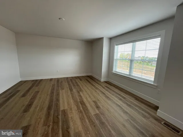 a view of an empty room and wooden floor