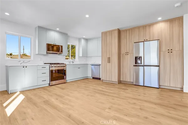 a view of kitchen with stainless steel appliances granite countertop a refrigerator and a stove top oven