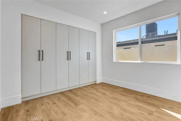 a view of an empty room with closet and a window