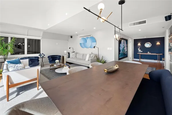 a living room with stainless steel appliances kitchen island granite countertop furniture and a large window
