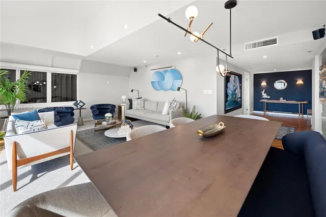 a living room with stainless steel appliances kitchen island granite countertop furniture and a large window