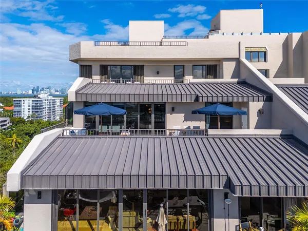 a view of a patio with couches dining table and chairs with wooden floor