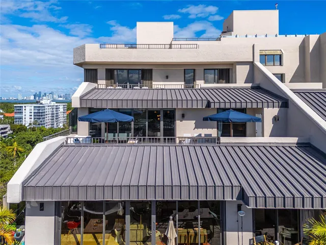 a view of a patio with couches dining table and chairs with wooden floor