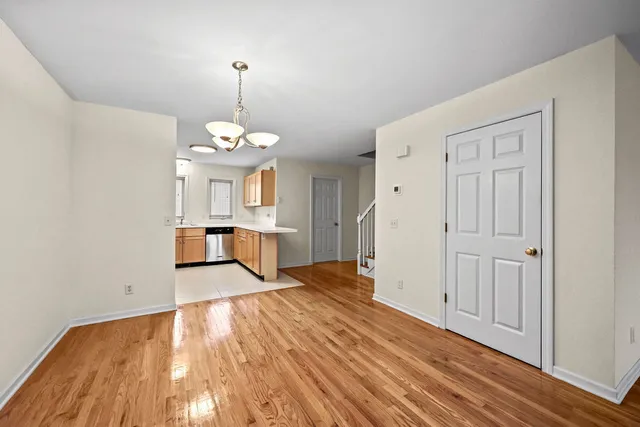 a view of a room with wooden floor staircase and a kitchen space