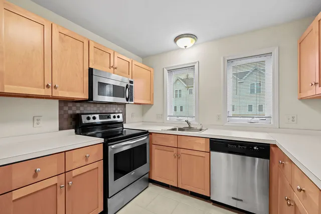 a kitchen with stainless steel appliances granite countertop a sink and a refrigerator