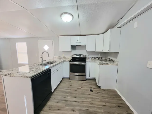 a kitchen with granite countertop white cabinets and white appliances