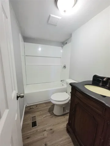 a bathroom with a granite countertop toilet sink and mirror