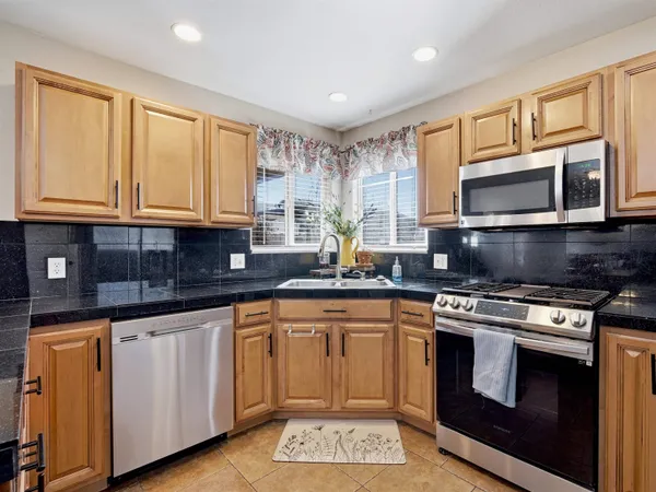 a kitchen with stainless steel appliances granite countertop a stove sink microwave and cabinets
