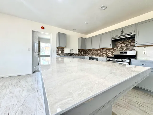 a kitchen with stainless steel appliances granite countertop a sink stove and cabinets