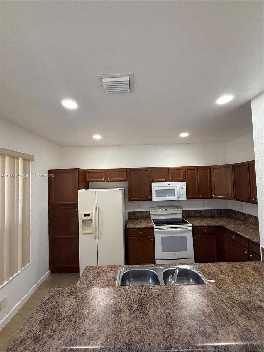 9248 Southwest 170th Place, Unit 9248 Miami, FL 33196 - Photo 13 of 30 a view of kitchen with refrigerator and microwave