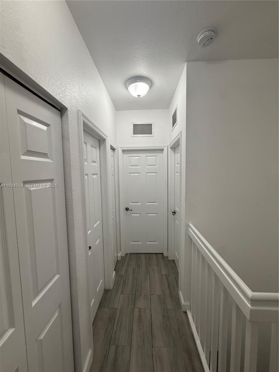 9248 Southwest 170th Place, Unit 9248 Miami, FL 33196 - Photo 23 of 30 a view of a hallway with wooden floor