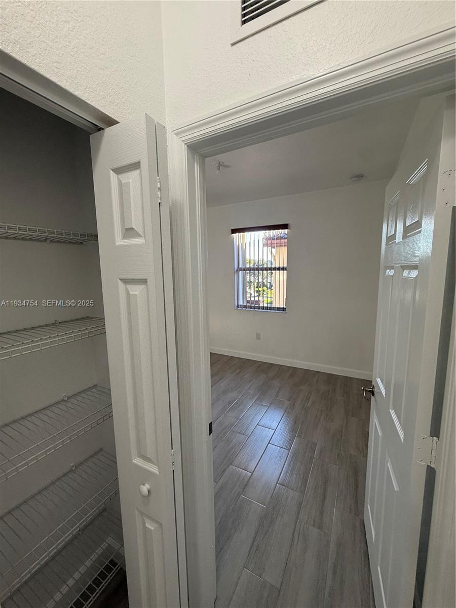 9248 Southwest 170th Place, Unit 9248 Miami, FL 33196 - Photo 28 of 30 a view of an empty room and wooden floor