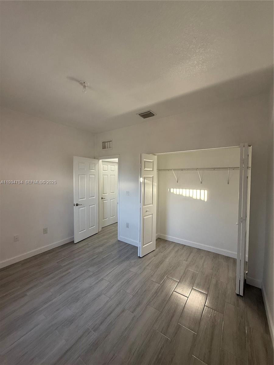 9248 Southwest 170th Place, Unit 9248 Miami, FL 33196 - Photo 29 of 30 a view of wooden floor and windows in an empty room