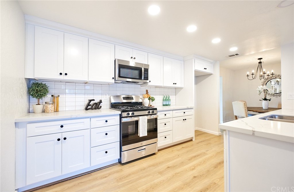 16061 Suttles Drive Riverside, CA 92504 - Photo 5 of 36 a kitchen with white cabinets stainless steel appliances and sink