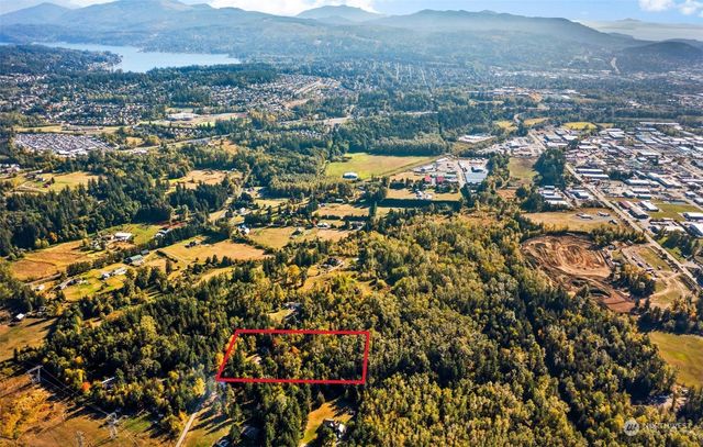 an aerial view of residential house with parking and trees