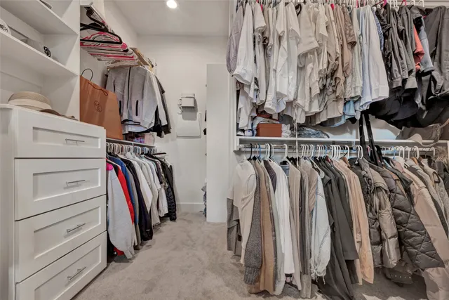 a view of walk in closet with clothes