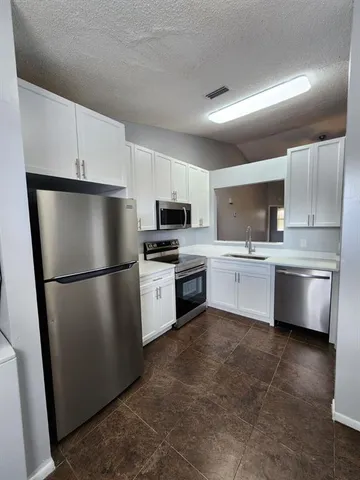 a kitchen with a refrigerator a sink and a microwave