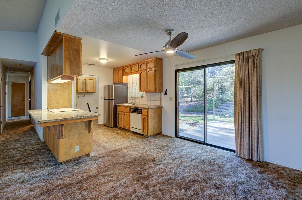 27266 Twin Ponds Road Clovis, CA 93619 - Photo 14 of 45 a large kitchen with kitchen island a large window a sink and stainless steel appliances