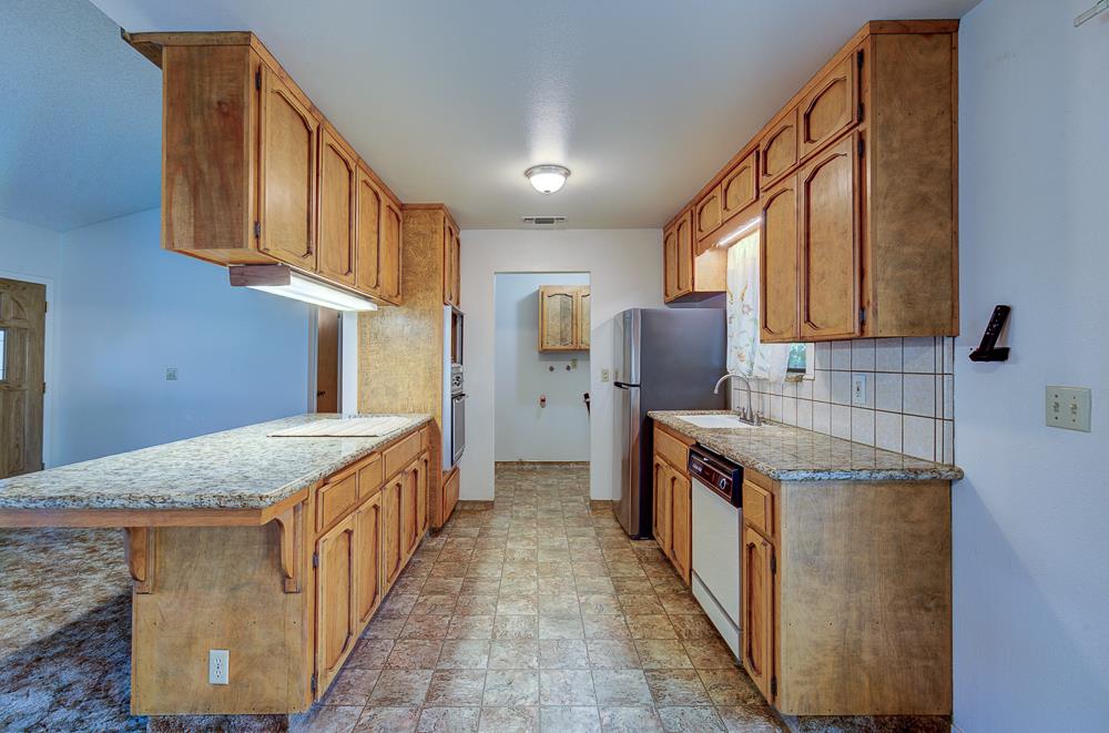 27266 Twin Ponds Road Clovis, CA 93619 - Photo 20 of 45 a kitchen with granite countertop a sink stove and cabinets