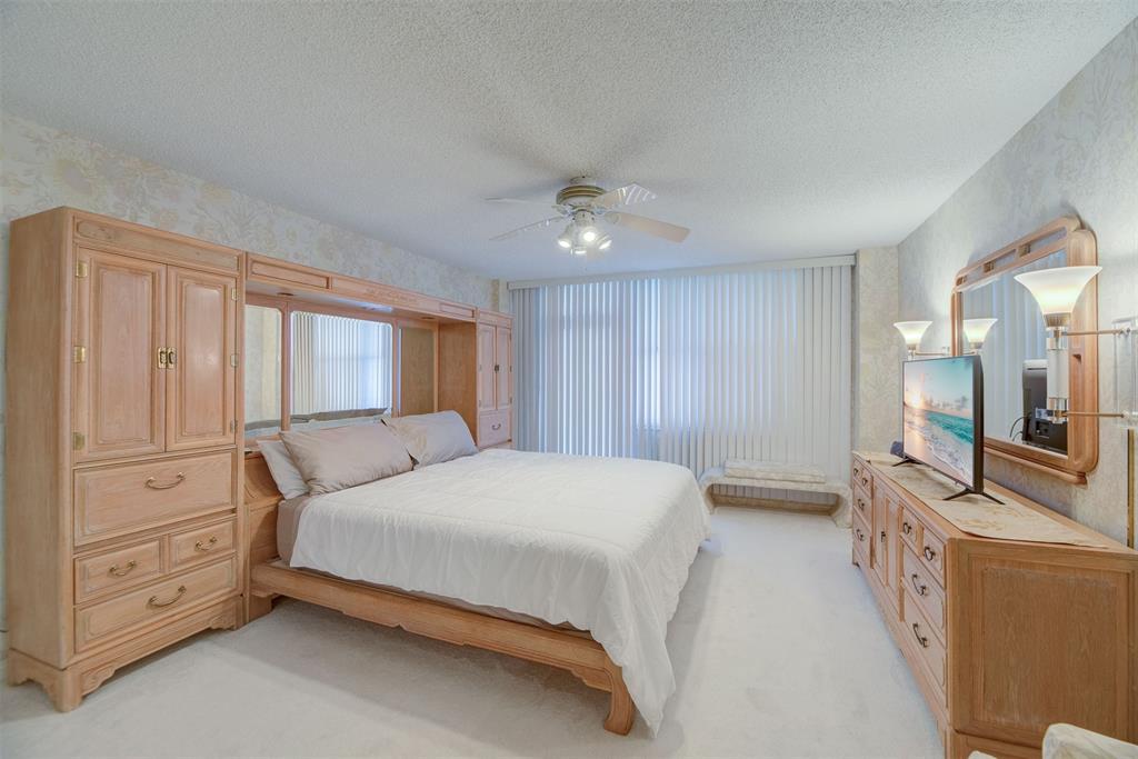 4600 South Ocean Boulevard, Unit 603 Highland Beach, FL 33487 - Photo 12 of 35 a bedroom with a large bed and a chandelier