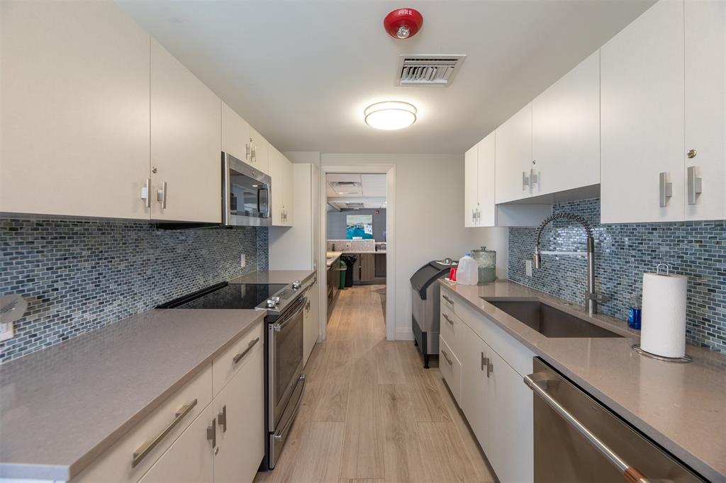 4600 South Ocean Boulevard, Unit 603 Highland Beach, FL 33487 - Photo 25 of 35 a kitchen with kitchen island granite countertop a sink a counter space stainless steel appliances and cabinets