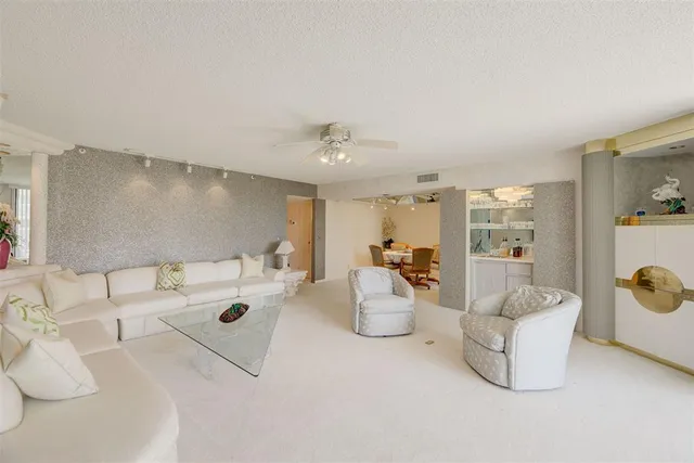 a view of a dining room with furniture and a chandelier fan