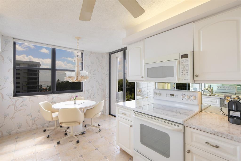 4600 South Ocean Boulevard, Unit 603 Highland Beach, FL 33487 - Photo 9 of 35 a living room with stainless steel appliances kitchen island granite countertop a sink a stove and white cabinets with wooden floor