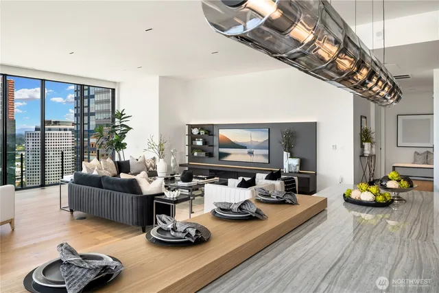 a living room with furniture kitchen view and large windows