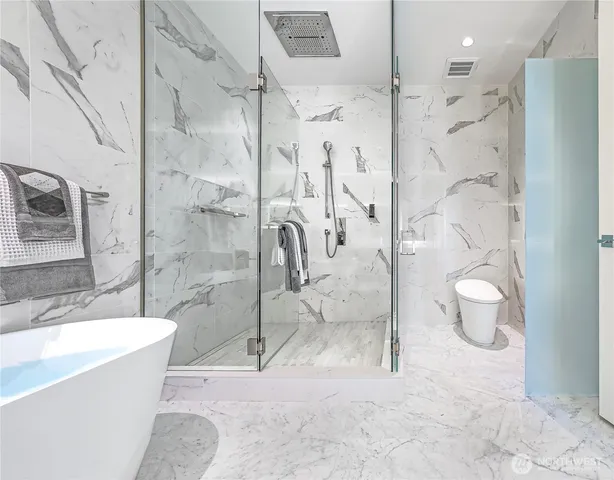 a bathroom with a granite countertop bathtub shower sink and toilet