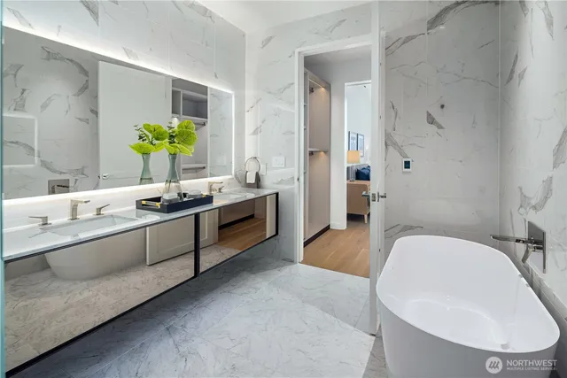 a spacious bathroom with a tub sink and mirror