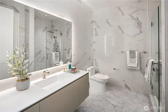 a bathroom with a granite countertop sink a toilet and a shower