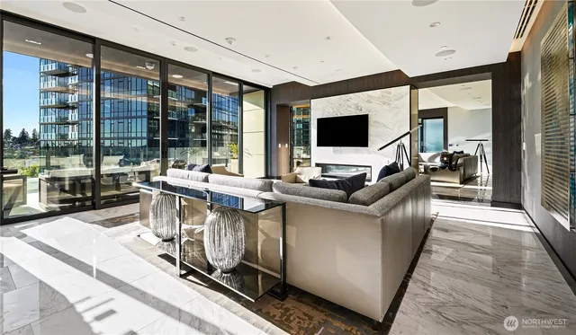 a living room with furniture a flat screen tv and a floor to ceiling window