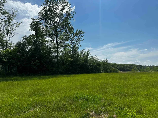 a view of a green field with wooden fence