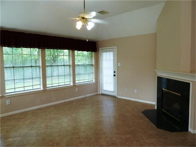 4542 Springfield Lakes Street Sugar Land, TX 77479 - Photo 4 of 16 Open family room with fireplace, ceiling fan, and expansive wall of windows overlooking the backyard.